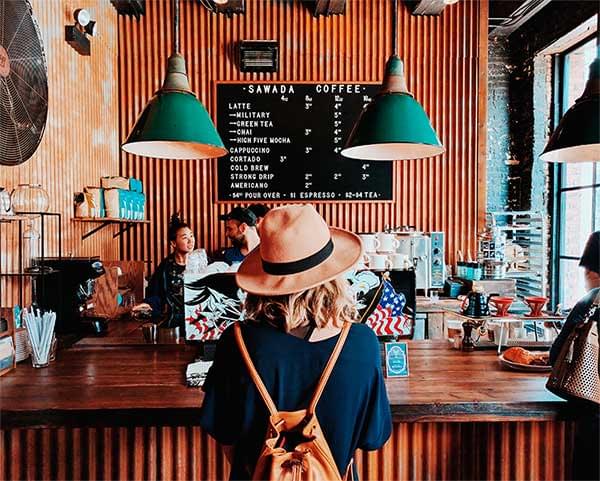 Imagen de una chica de espaldas pidiendo un café